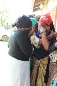 women crying whilst huddled together